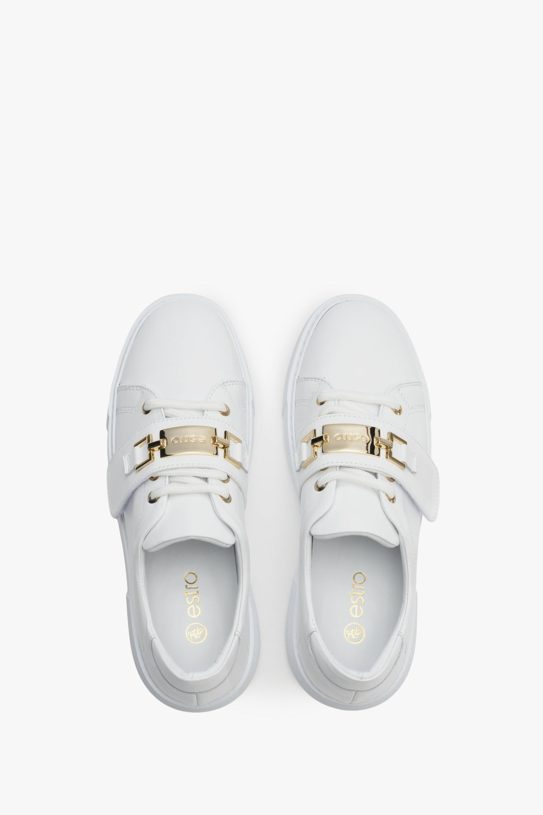 Women's white sneakers made of genuine leather with gold accents - top view shoe presentation.