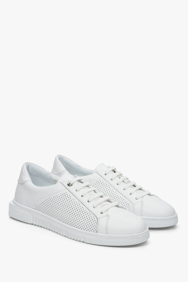 Women's white leather sneakers with perforation and lacing - close-up of the side seam and toe cap.