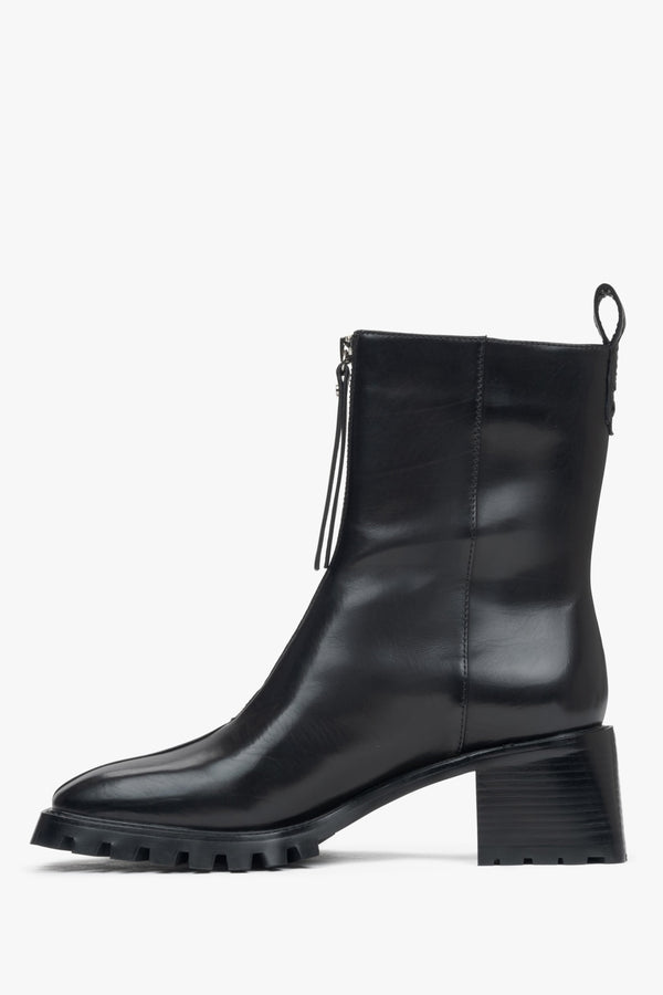 Stylish women's black ankle boots made of genuine leather with a low heel - side view of the shoe.