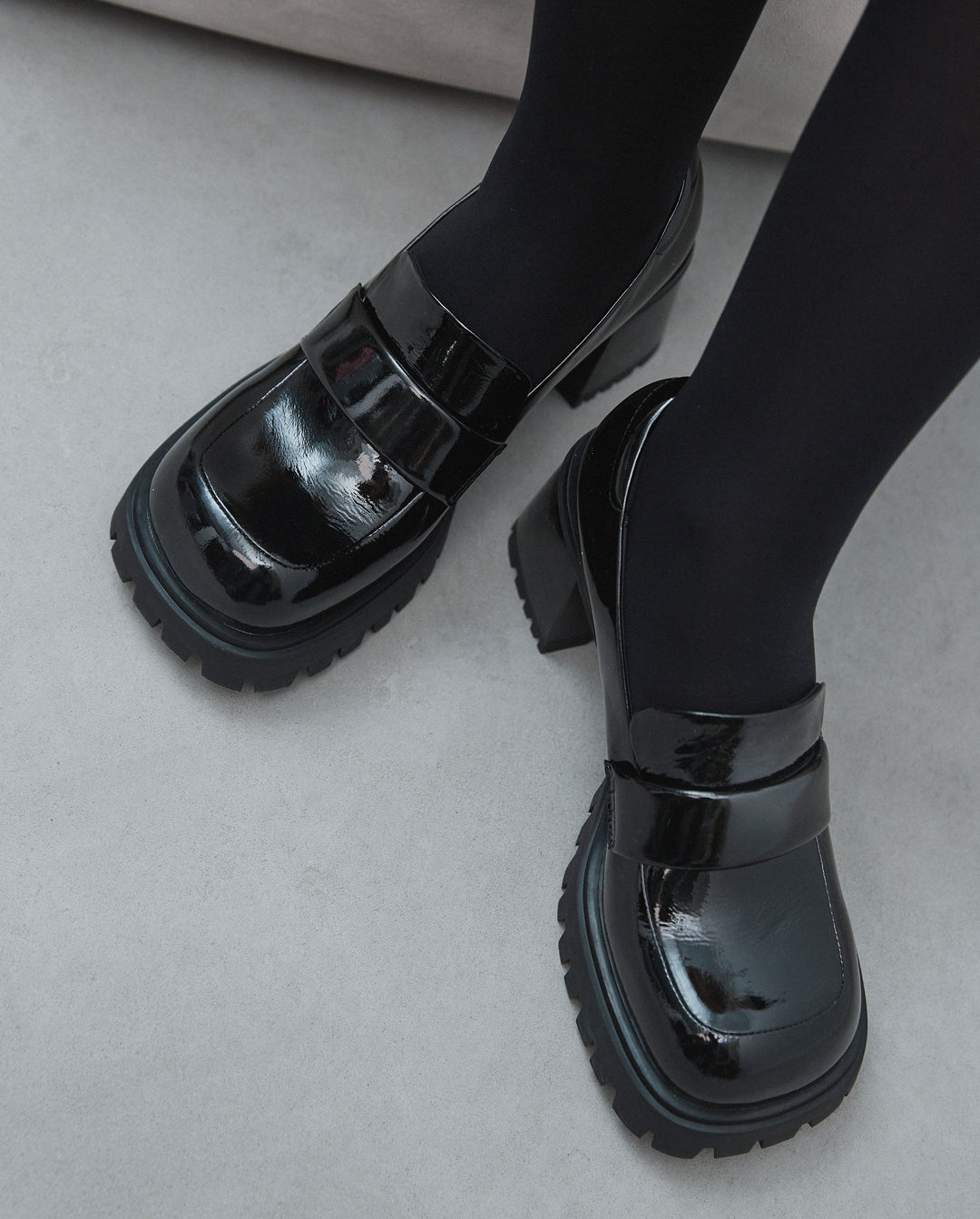 Women's leather patent black heeled moccasins - presentation on a model.