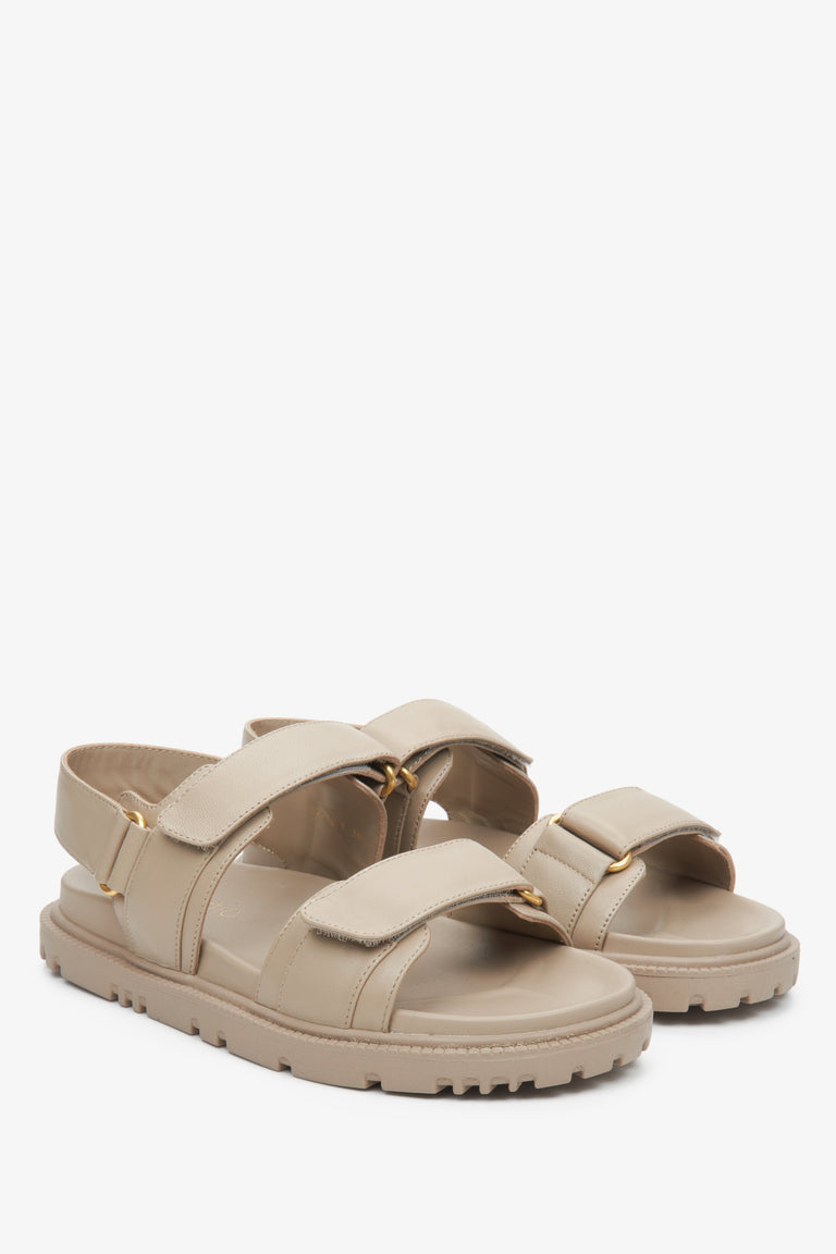 Women's beige sandals with a flexible sole and golden embellishments.