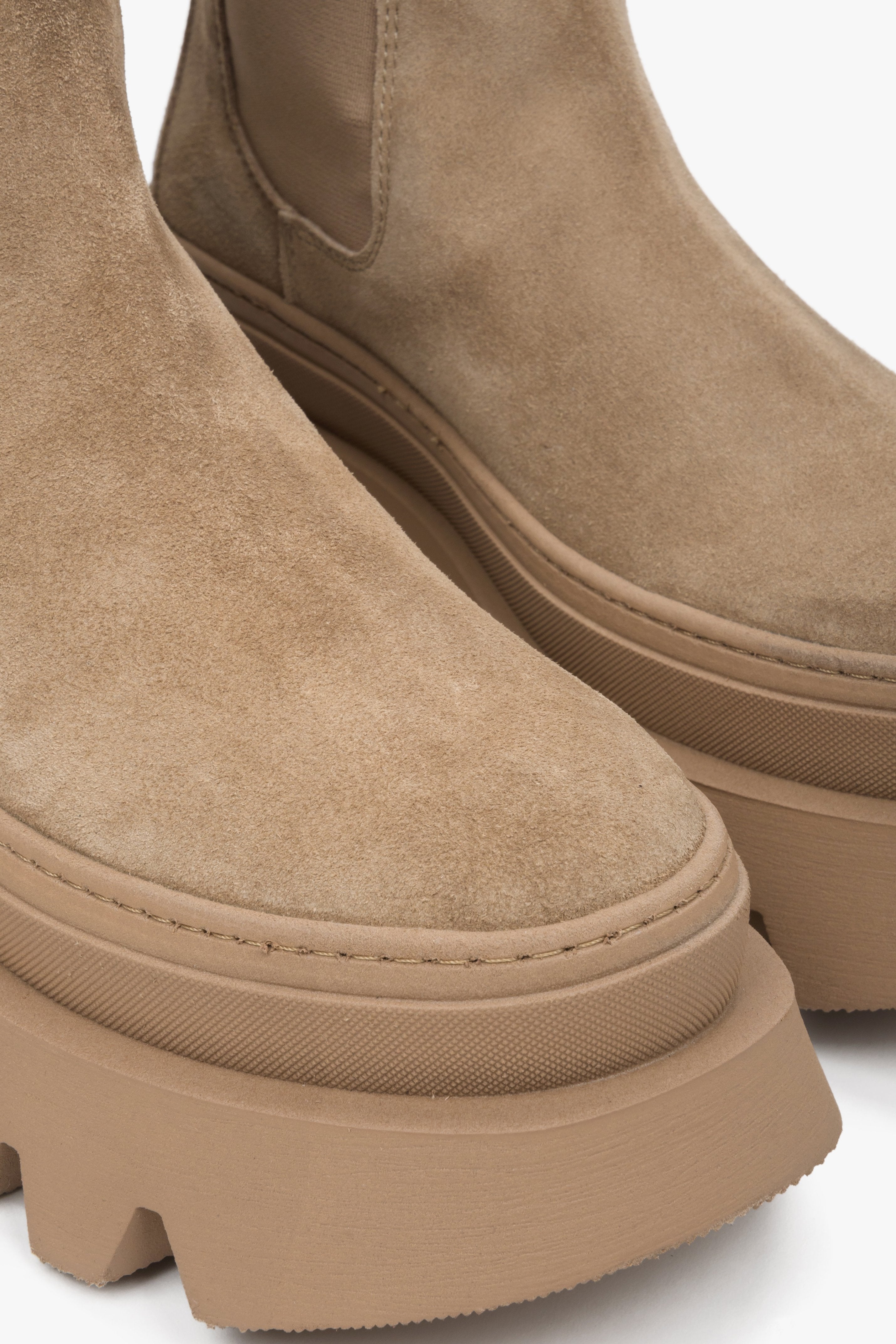 Stylish women's brown ankle boots on a thick sole by Estro - close-up on the rounded toe of the model.