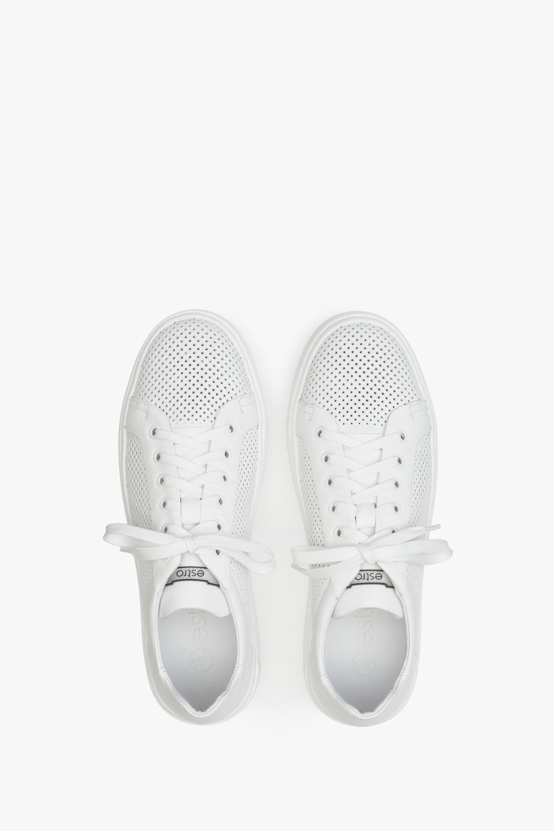 Men's white leather summer sneakers with perforation - presentation of the footwear from the top.