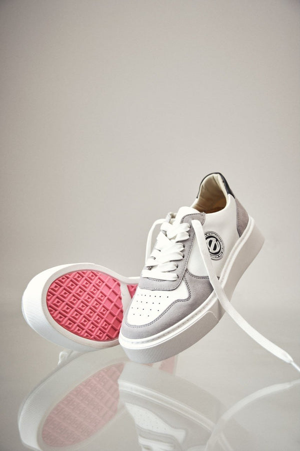 Women's sneakers made of natural leather in white and grey color.