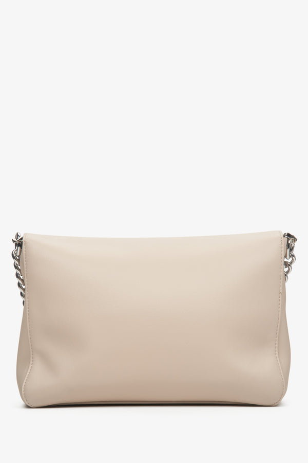 Women's light beige leather crossbody bag Estro with a chain - back view of the model.