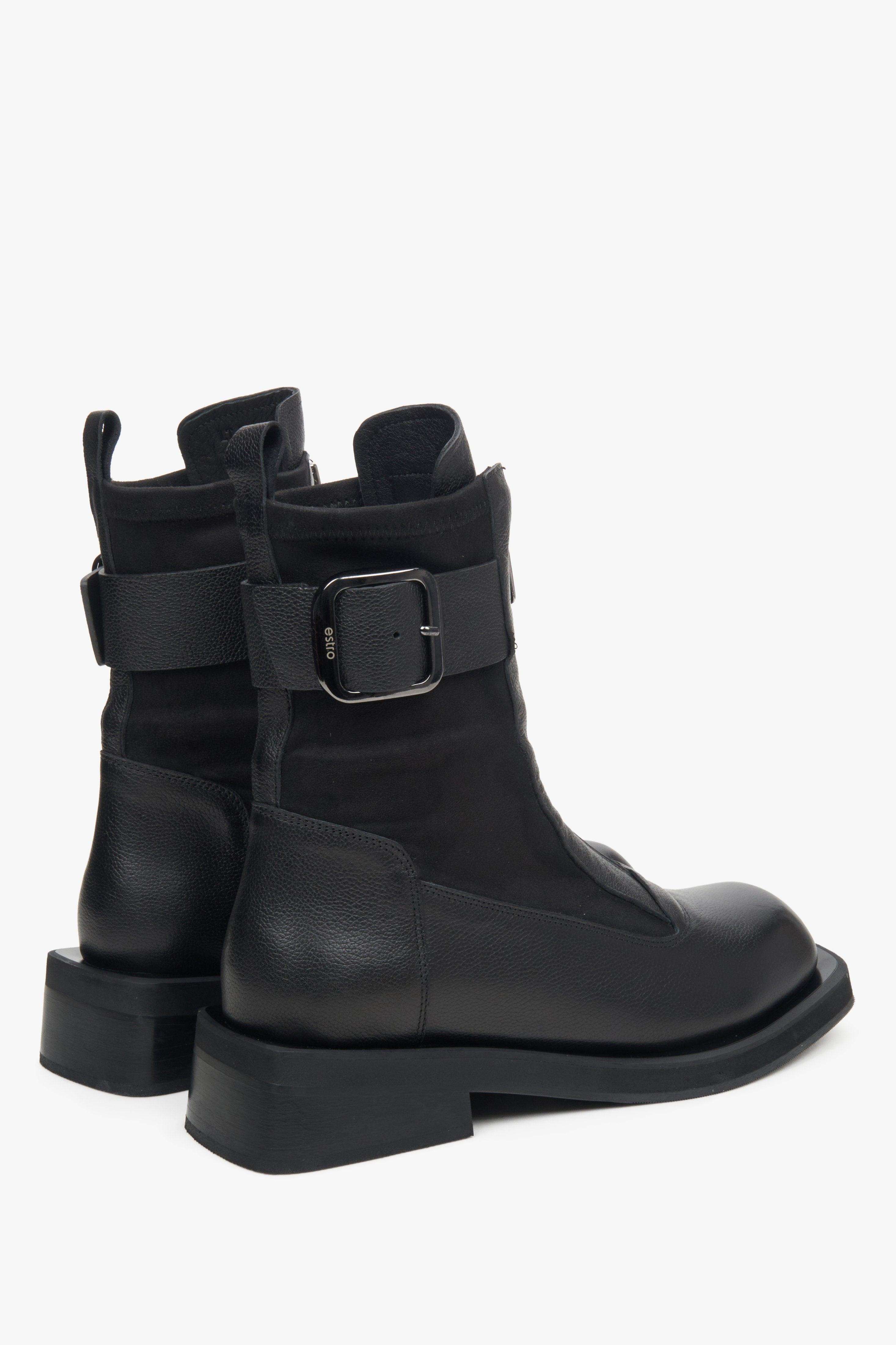 Women's black leather Estro ankle boots with decorative buckle - close-up of the side seam and heel counter.