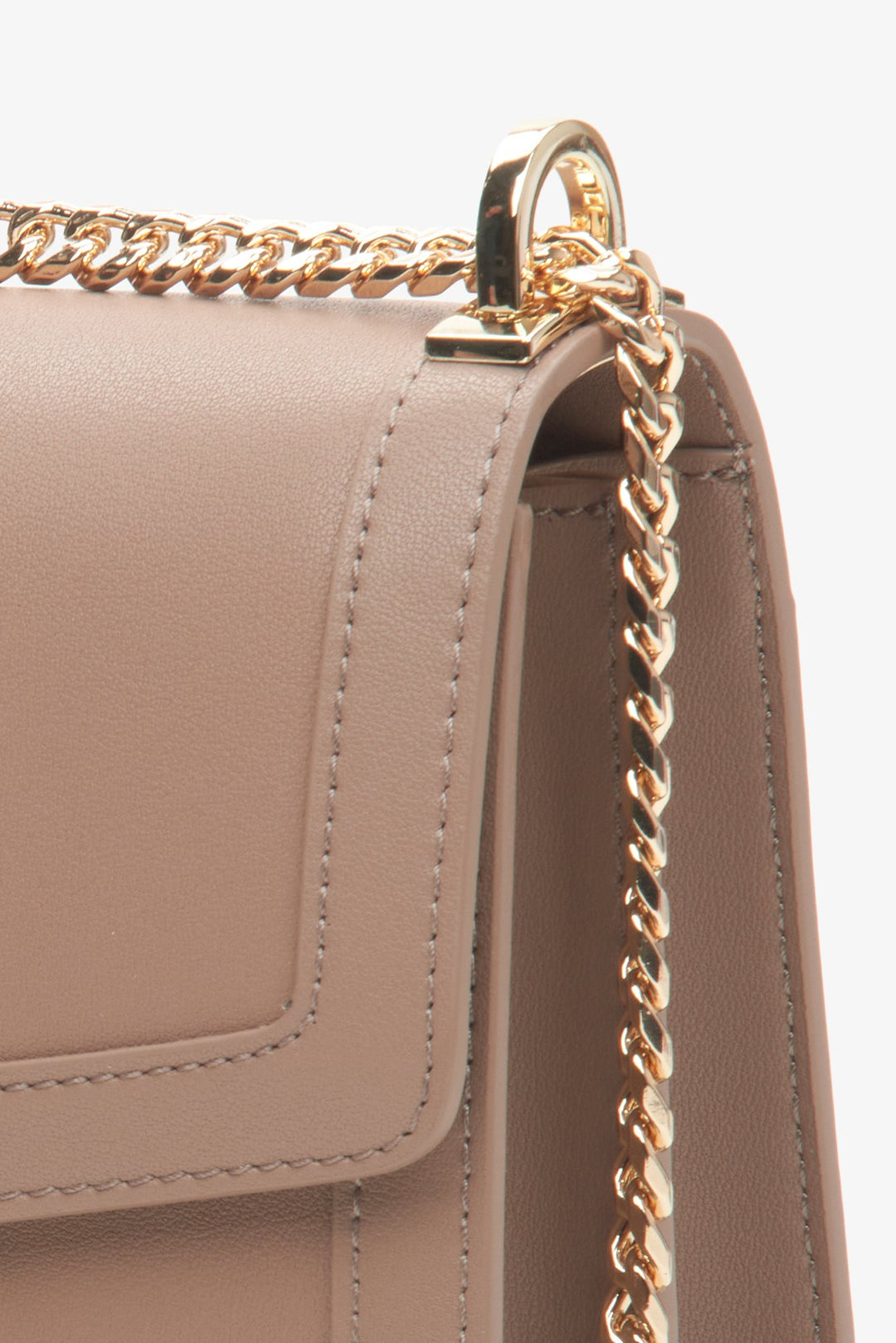 Women's leather brown handbag with a golden chain - close up on details.