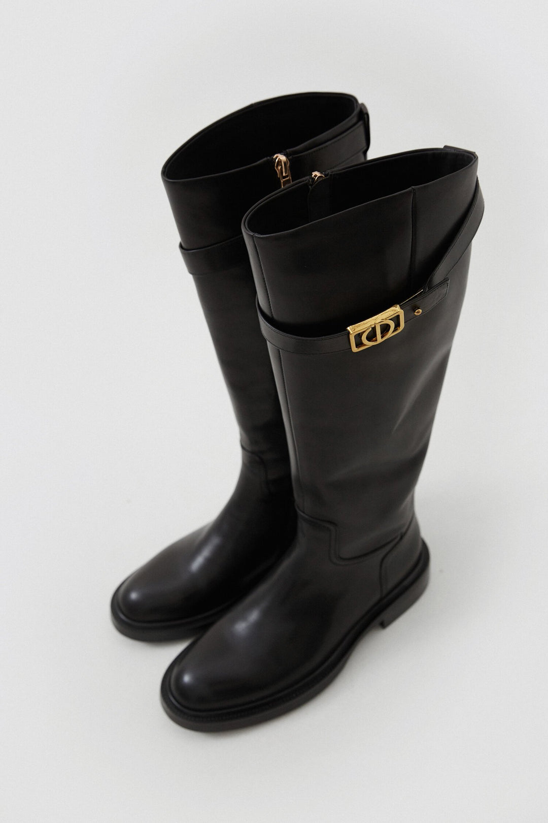 Women's black leather boots with decorative strap by Estro.