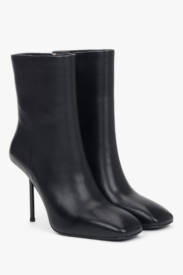 A pair of women's black leather ankle boots featuring a sharp stiletto heel.