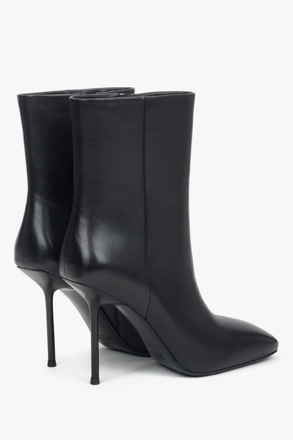 Side profile of a women's black leather ankle boot, highlighting the high stiletto heel.