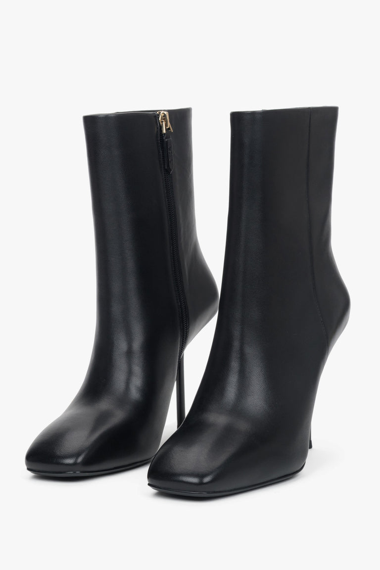Genuine leather crafted into a pair of women's black ankle boots with a high stiletto heel.