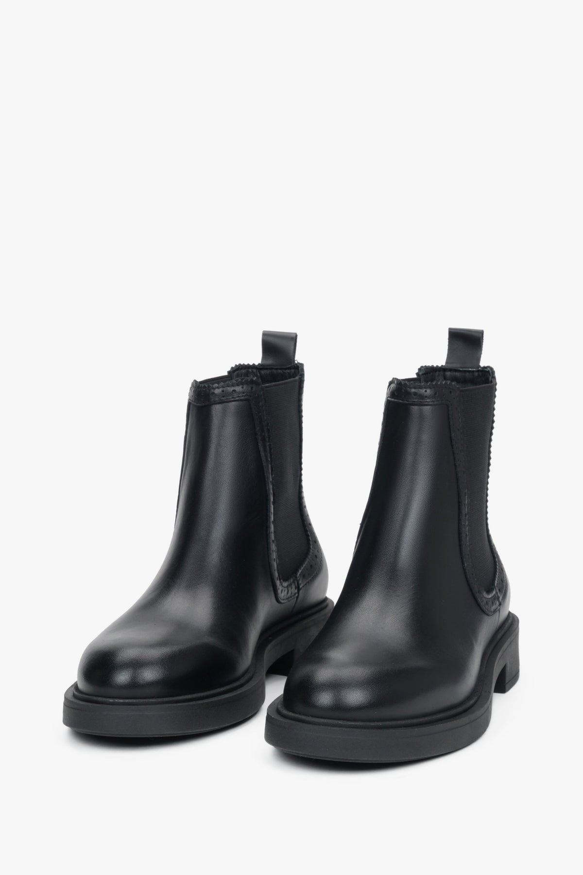 A pair of black women's Chelsea boots featuring decorative perforation on a premium Italian leather upper.