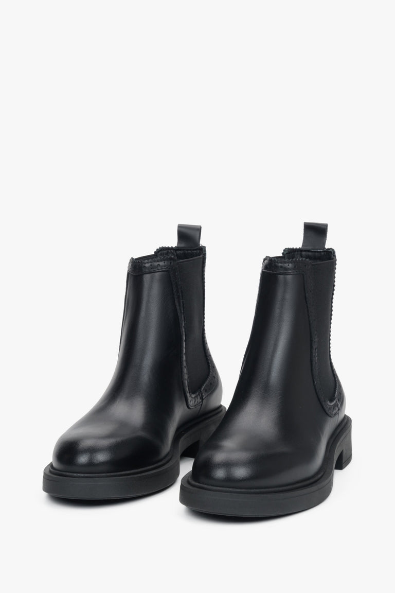 A pair of black women's Chelsea boots featuring decorative perforation on a premium Italian leather upper.