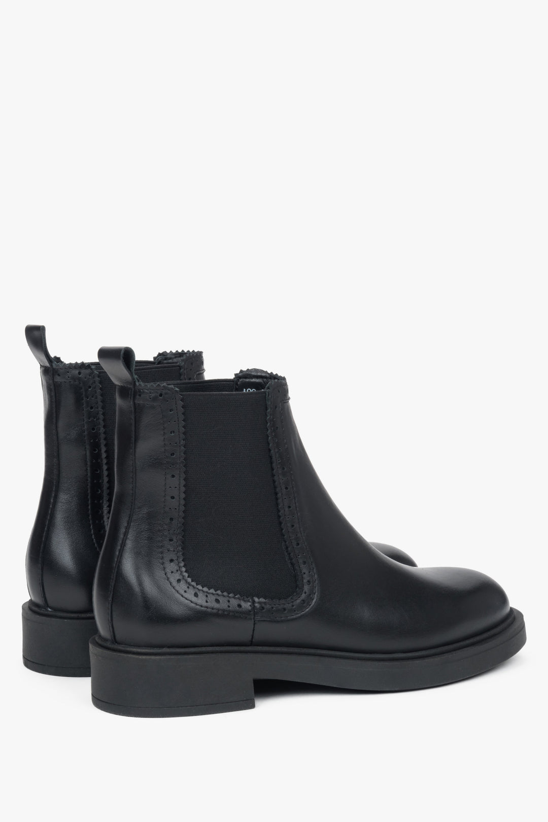 Side profile of a women's black Chelsea boot, showing the brogue-style perforation on the premium leather.