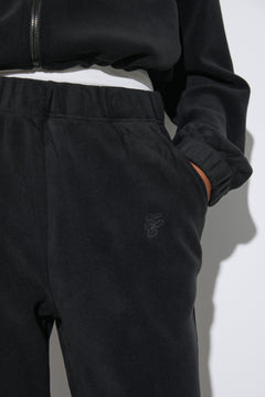 Women's black fleece tracksuit set Estro - close-up view highlighting the cozy fleece texture, hood detailing, and subtle finish.