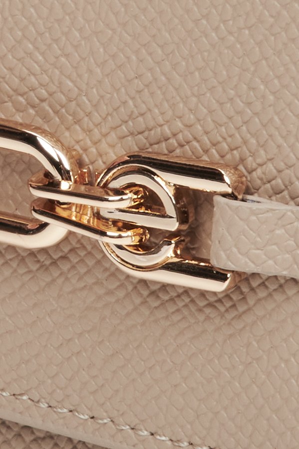 Women's beige leather small wallet with a gold clasp - close-up on details.