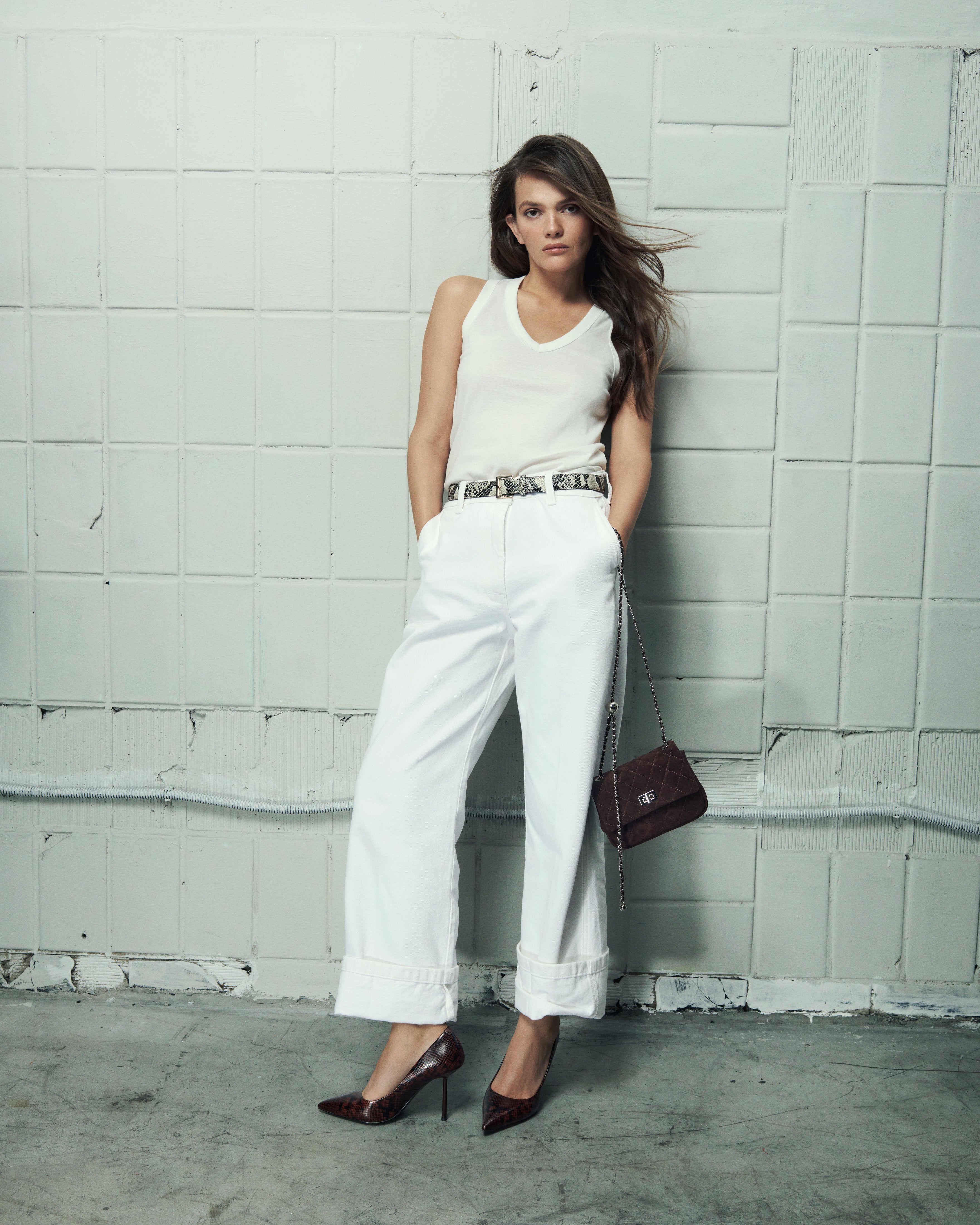 Side profile of a woman's brown high-heeled shoe, showing the detailed faux snakeskin texture.