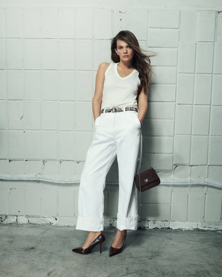 Side profile of a woman's brown high-heeled shoe, showing the detailed faux snakeskin texture.