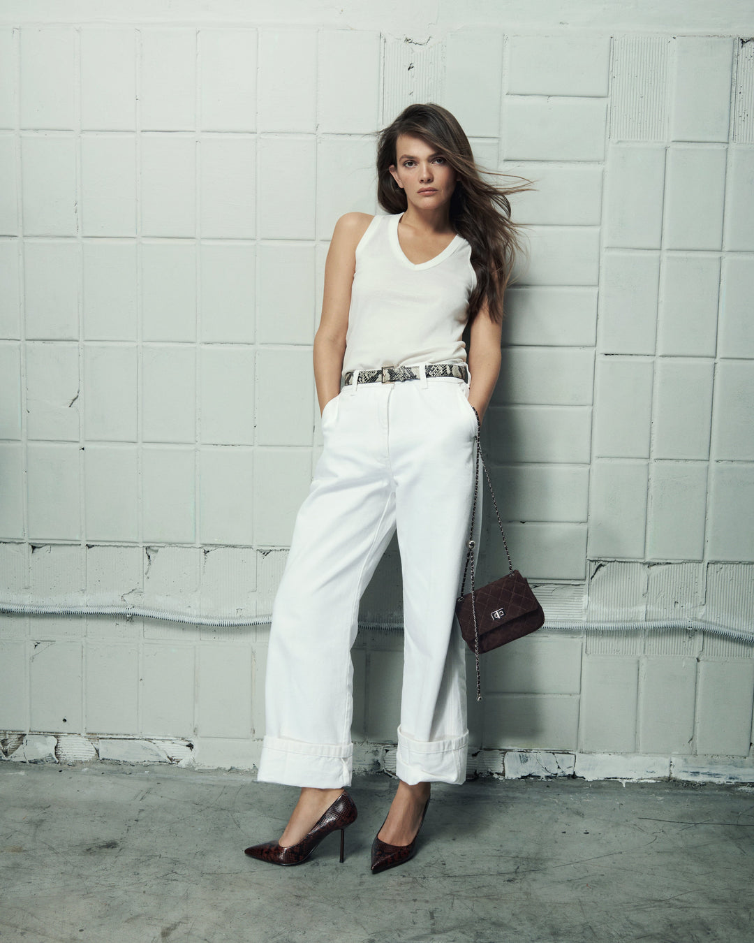 Side profile of a woman's brown high-heeled shoe, showing the detailed faux snakeskin texture.