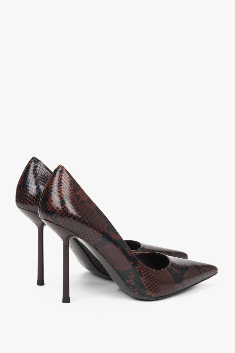 Side profile of a woman's brown high-heeled shoe, showing the detailed faux snakeskin texture.