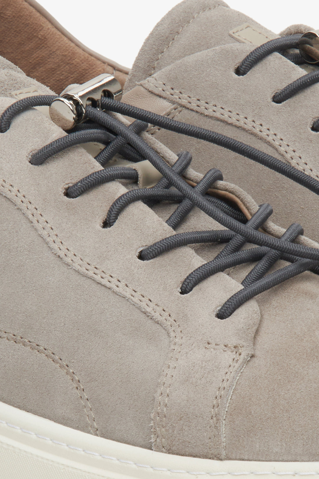 Grey men's suede sneakers - close-up of the fastening system and stitching.