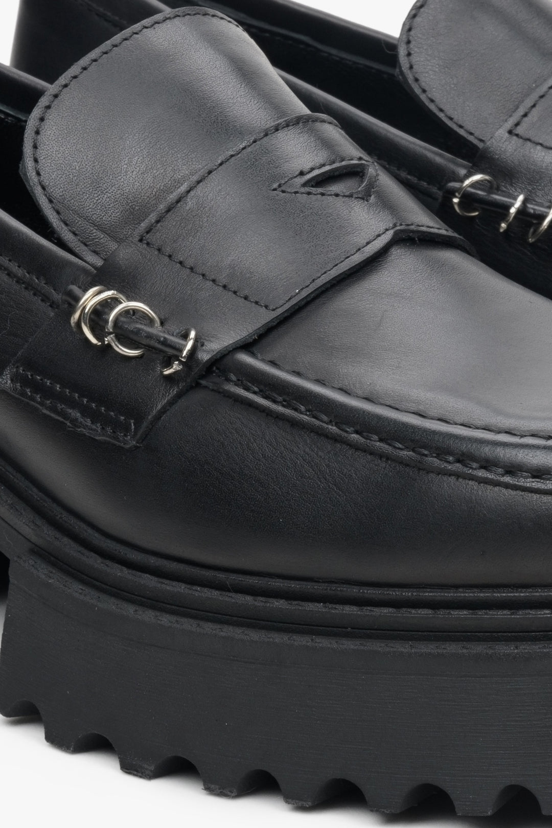Women's leather moccasins on a thick black sole - close-up on the detail.
