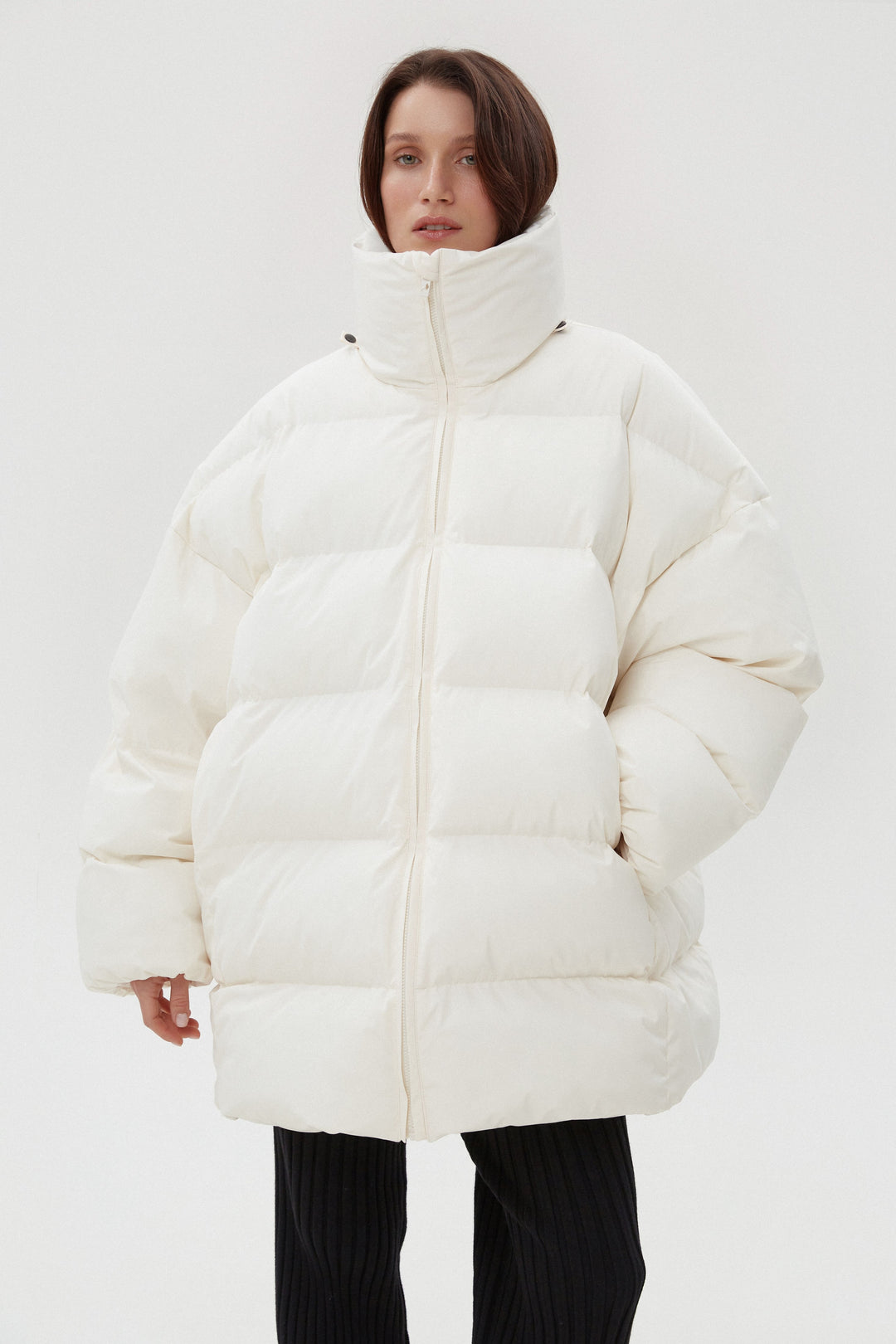 Light beige quilted women's puffer jacket with a high collar.