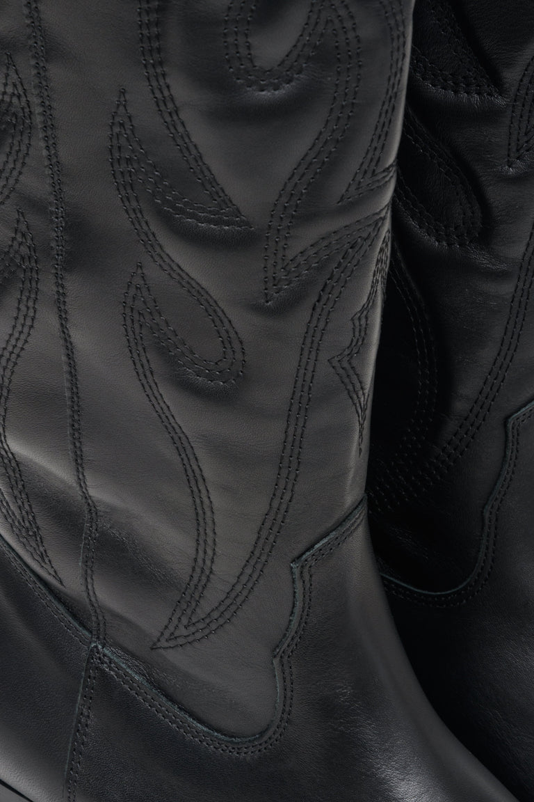 Women's black cowboy boots with embellishments made of genuine Italian leather - close-up on the details.