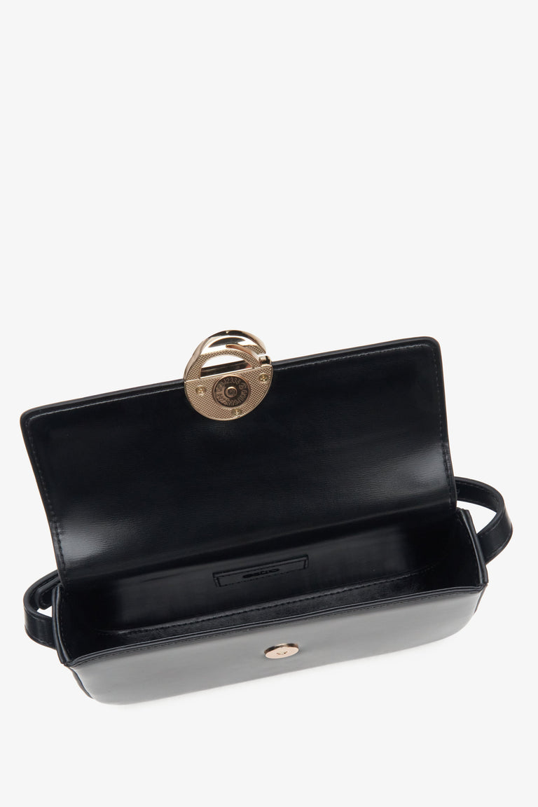 Women's small, black handbag made of genuine leather with golden hardware by Estro - close-up of the interior.