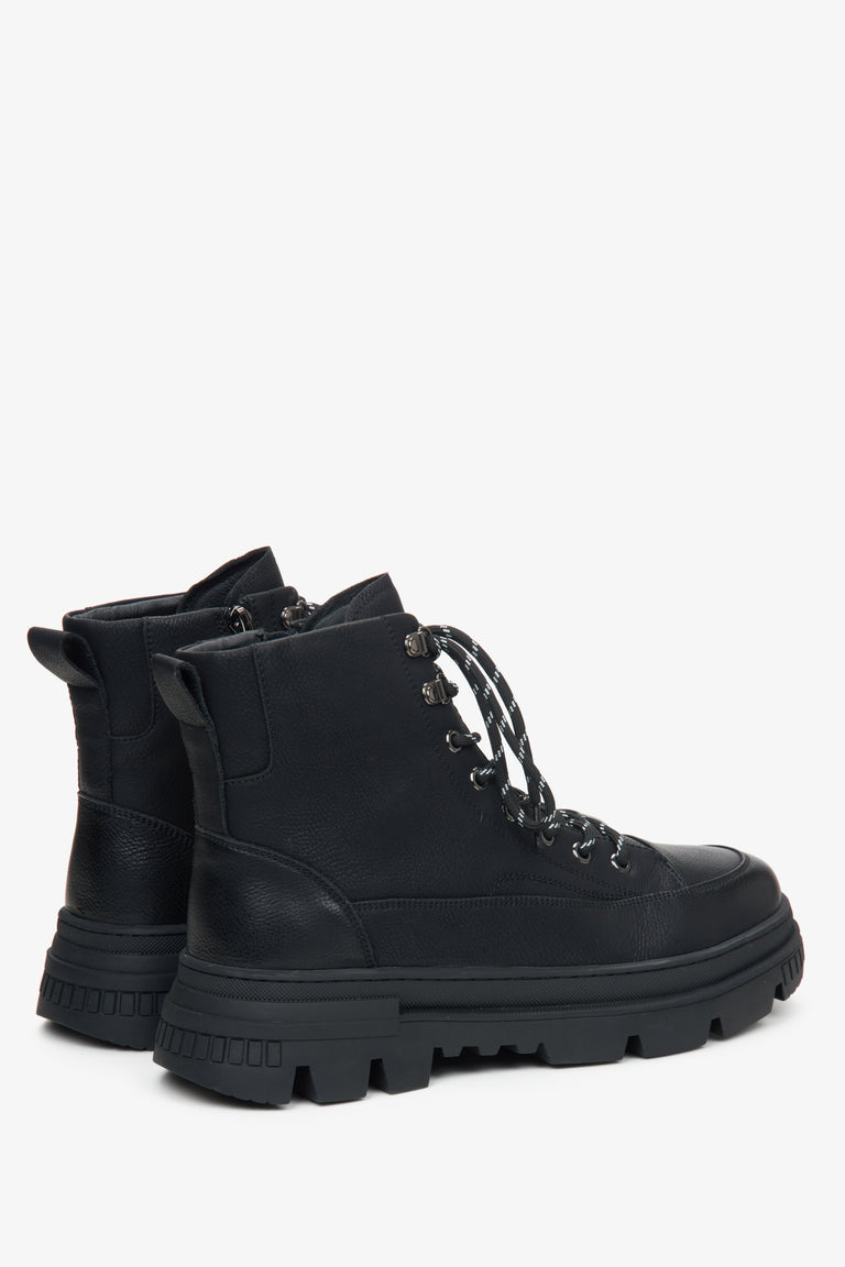 Men's black winter ankle boots with fur lining and decorative lacing by Estro – close-up of the heel and side line of the shoes.