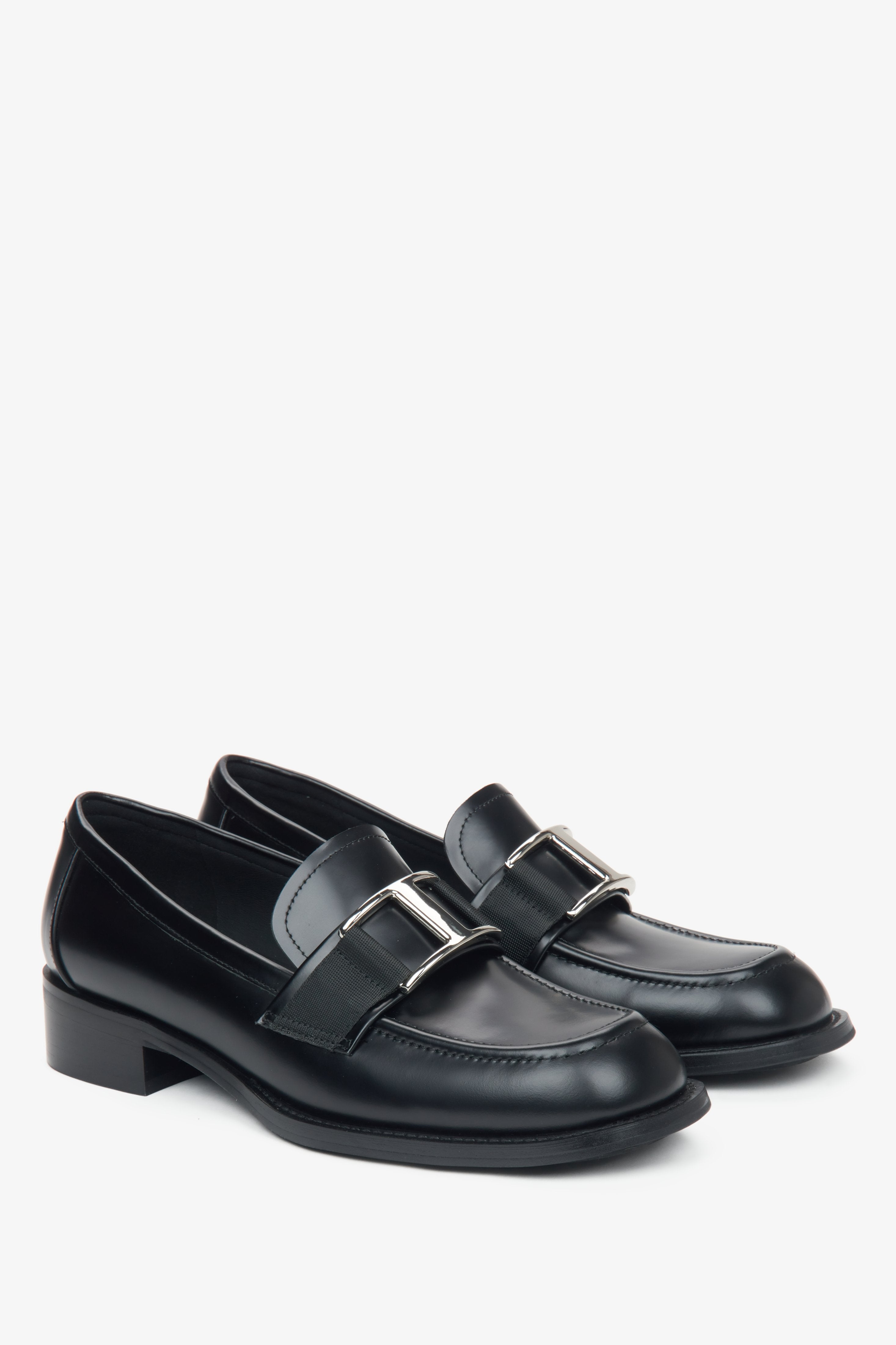 Estro black leather women's penny loafers with a decorative buckle.