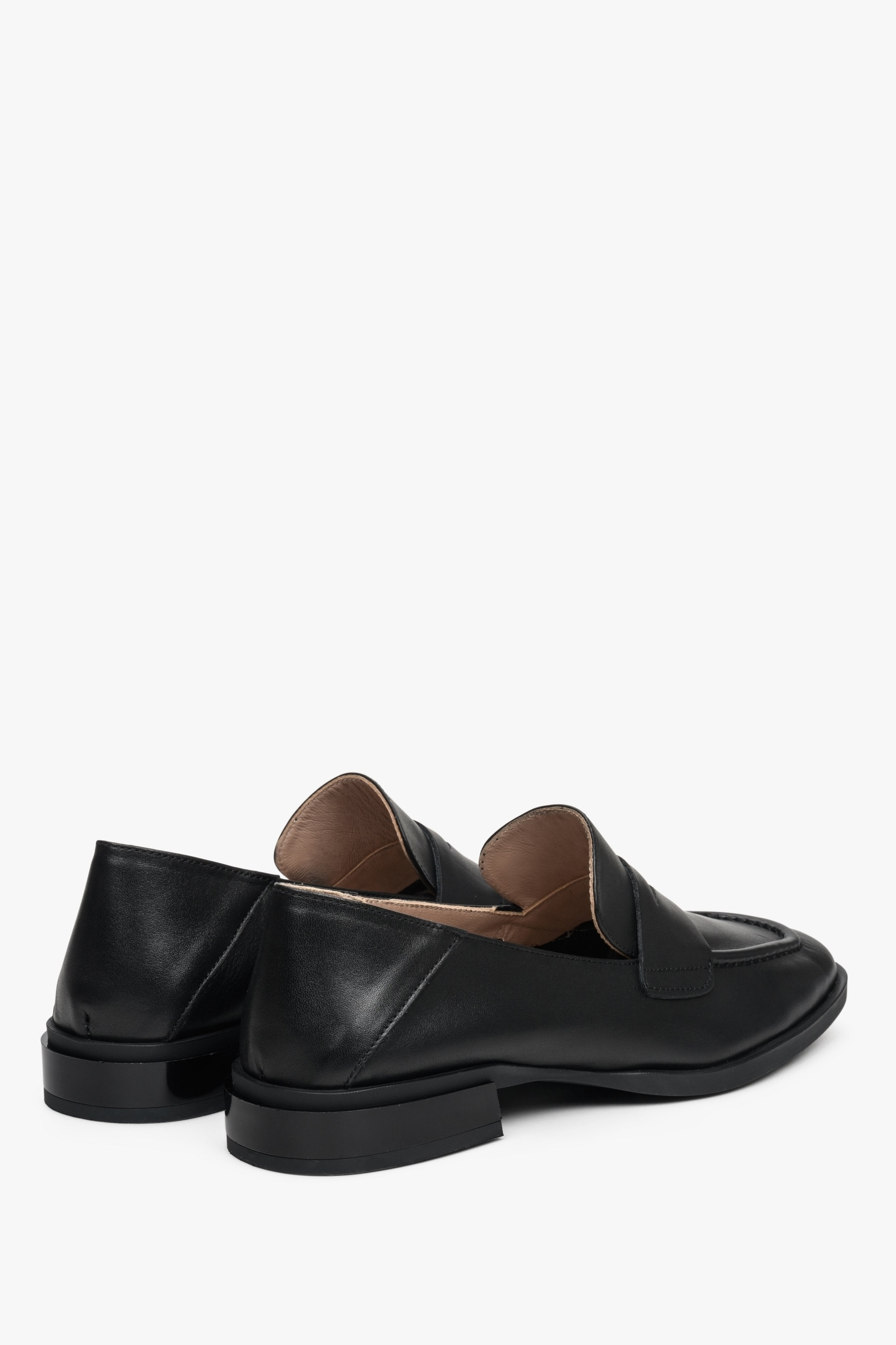 Women's black loafers made of genuine leather with a low heel - close-up on the heel and side seam.