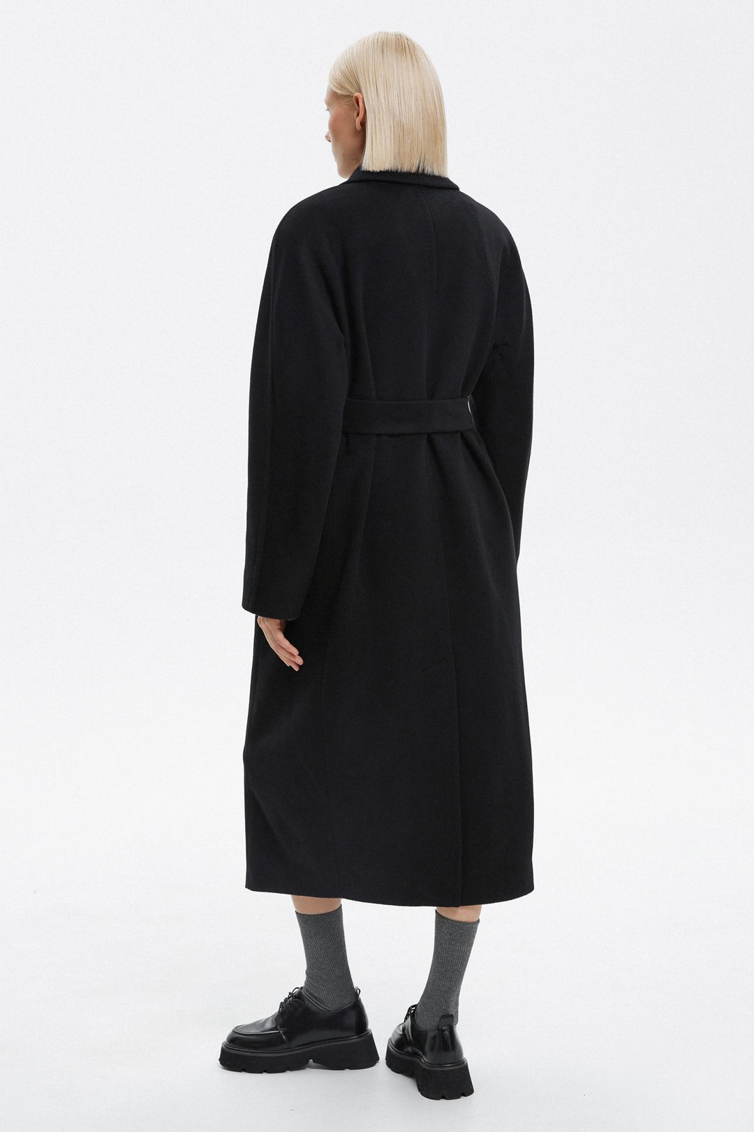 Women's black coat tied at the back by Estro - back of the model.