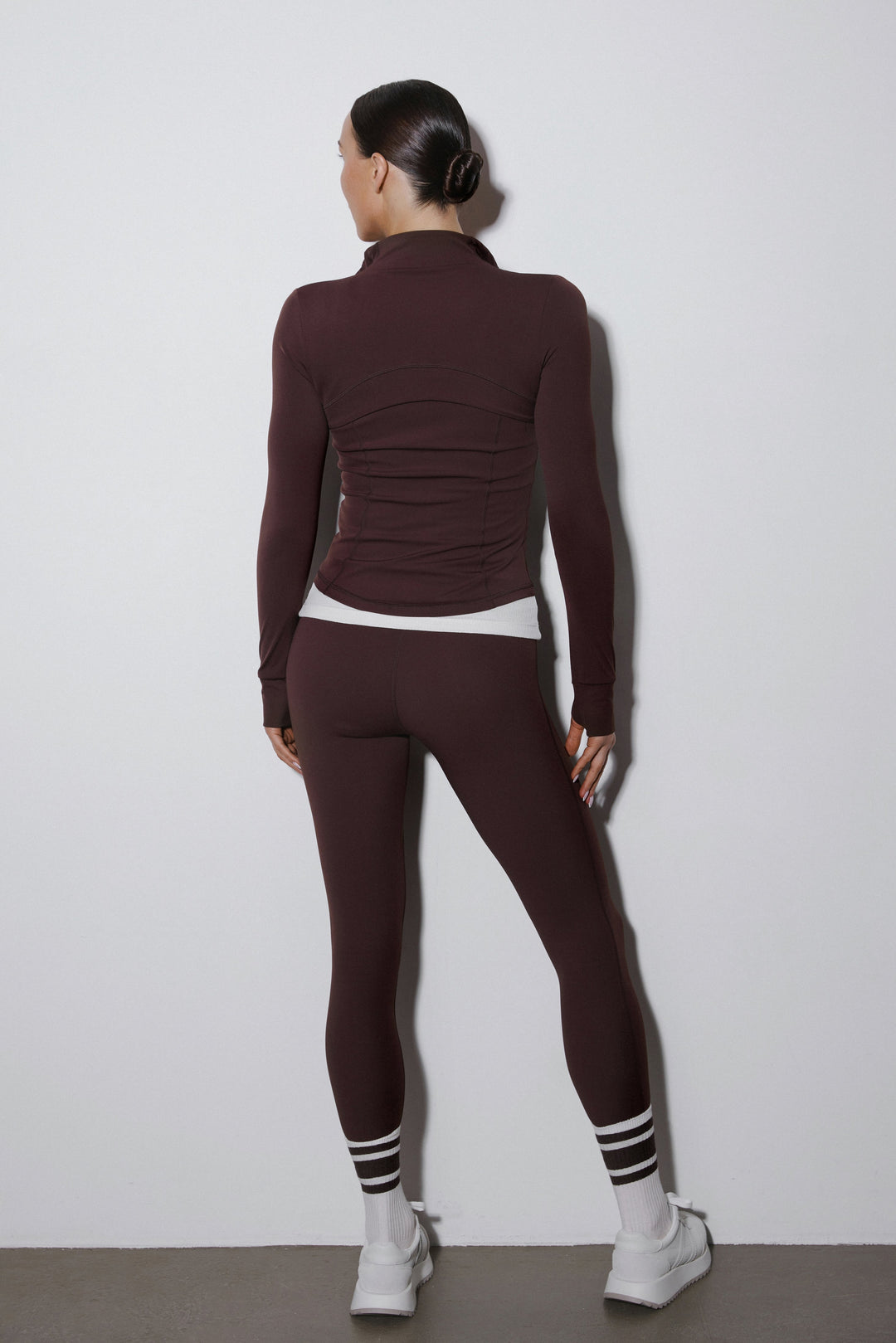 A dark brown tracksuit set from Estro featuring slim fit joggers and a stand-up collar sweatshirt.