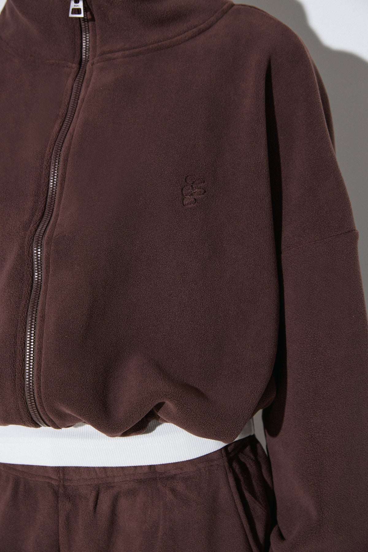 Women's dark brown fleece tracksuit set Estro - close-up view highlighting the soft fleece texture and detailed finish.