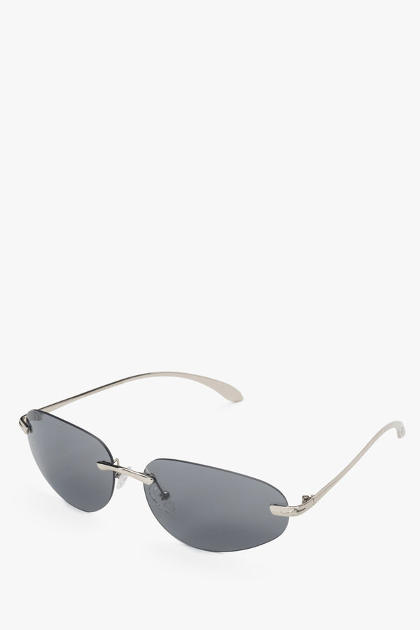 A pair of narrow, frameless sunglasses with dark grey lenses.