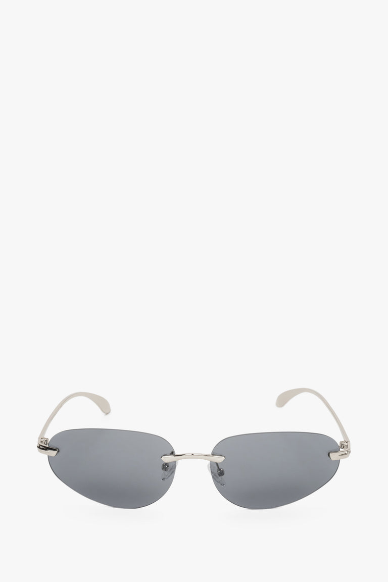 Dark grey narrow sunglasses for women with a rimless design.