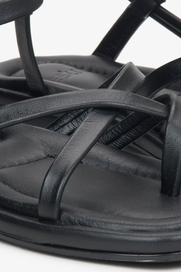 Women's black leather sandals with thin criss-crossed straps by Estro - close-up detail.