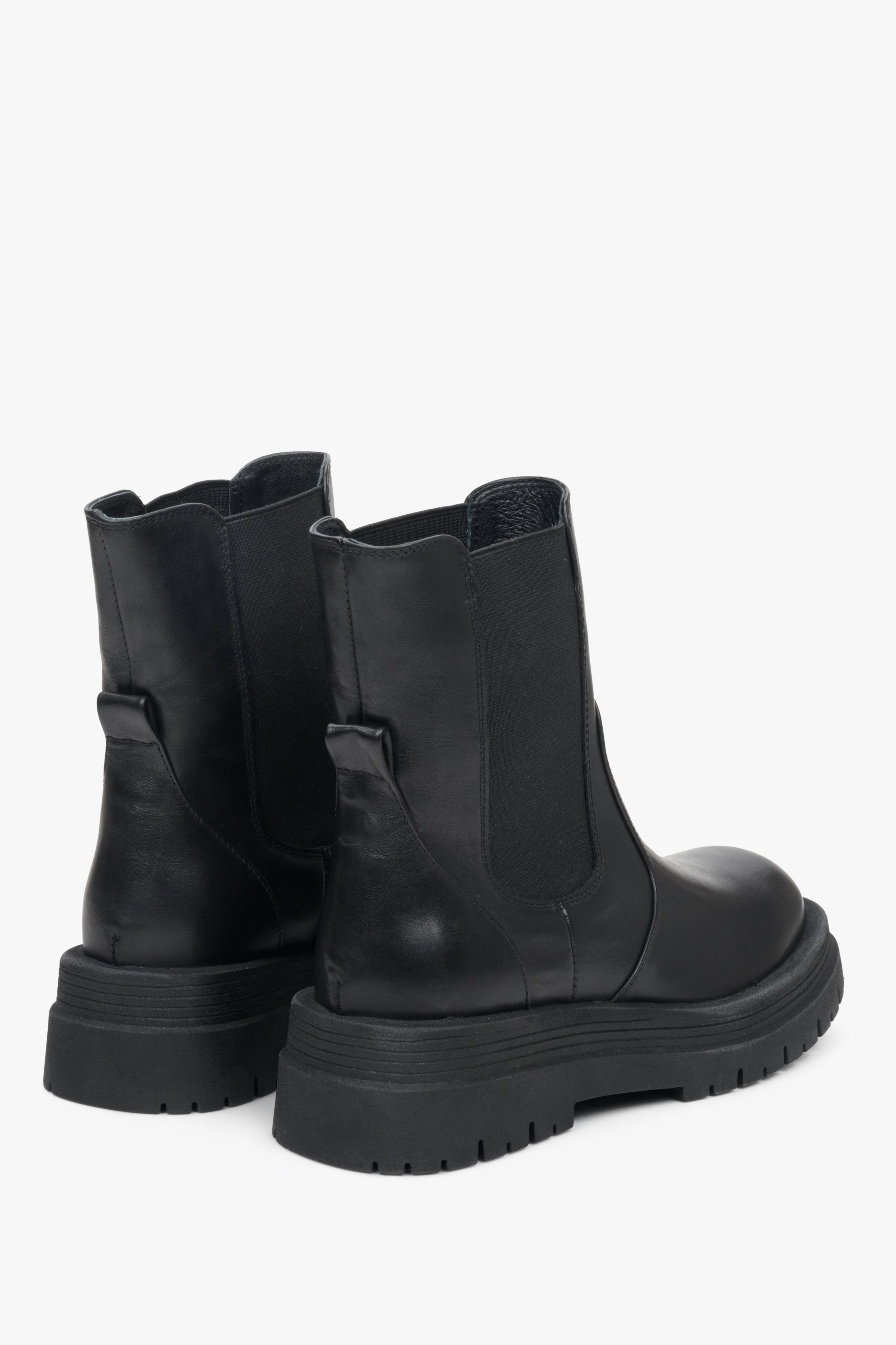 High women's fall ankle boots made of genuine black leather - close-up on the heel of the shoes.