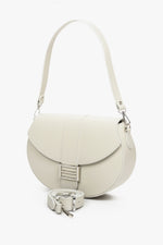 Women's light beige leather handbag with two adjustable straps by Estro - model presentation with a short handle.
