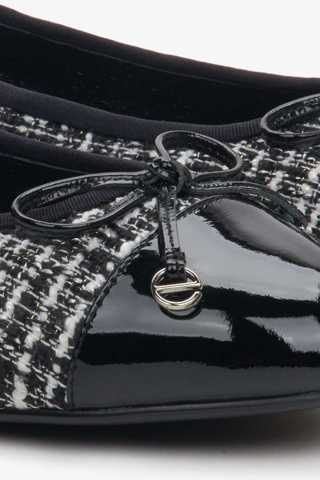 Women's black and white moccasins with a bow - close-up on the detail.