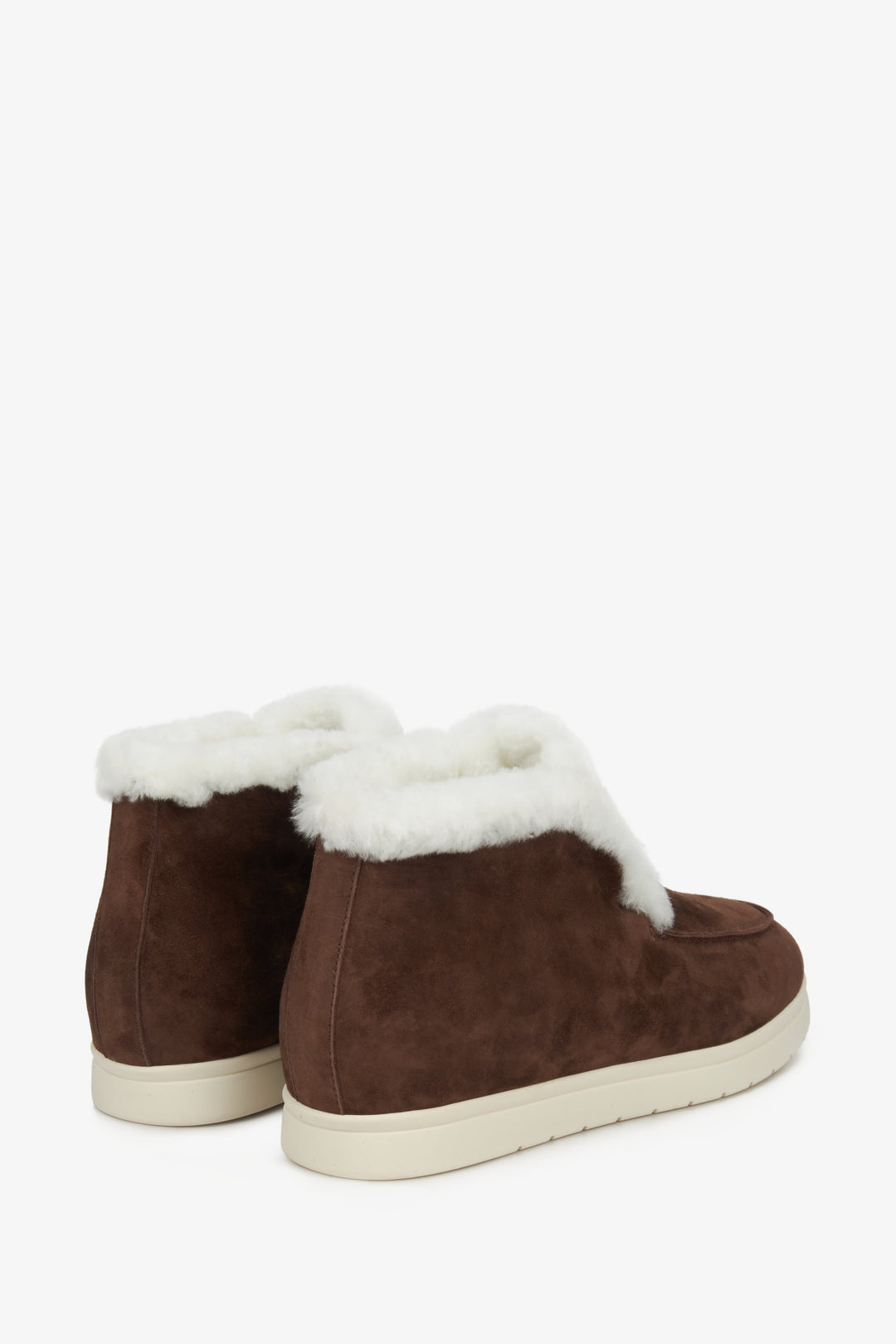 Elevated women's winter moccasins in brown suede with natural fur - close-up on the back of the shoe.