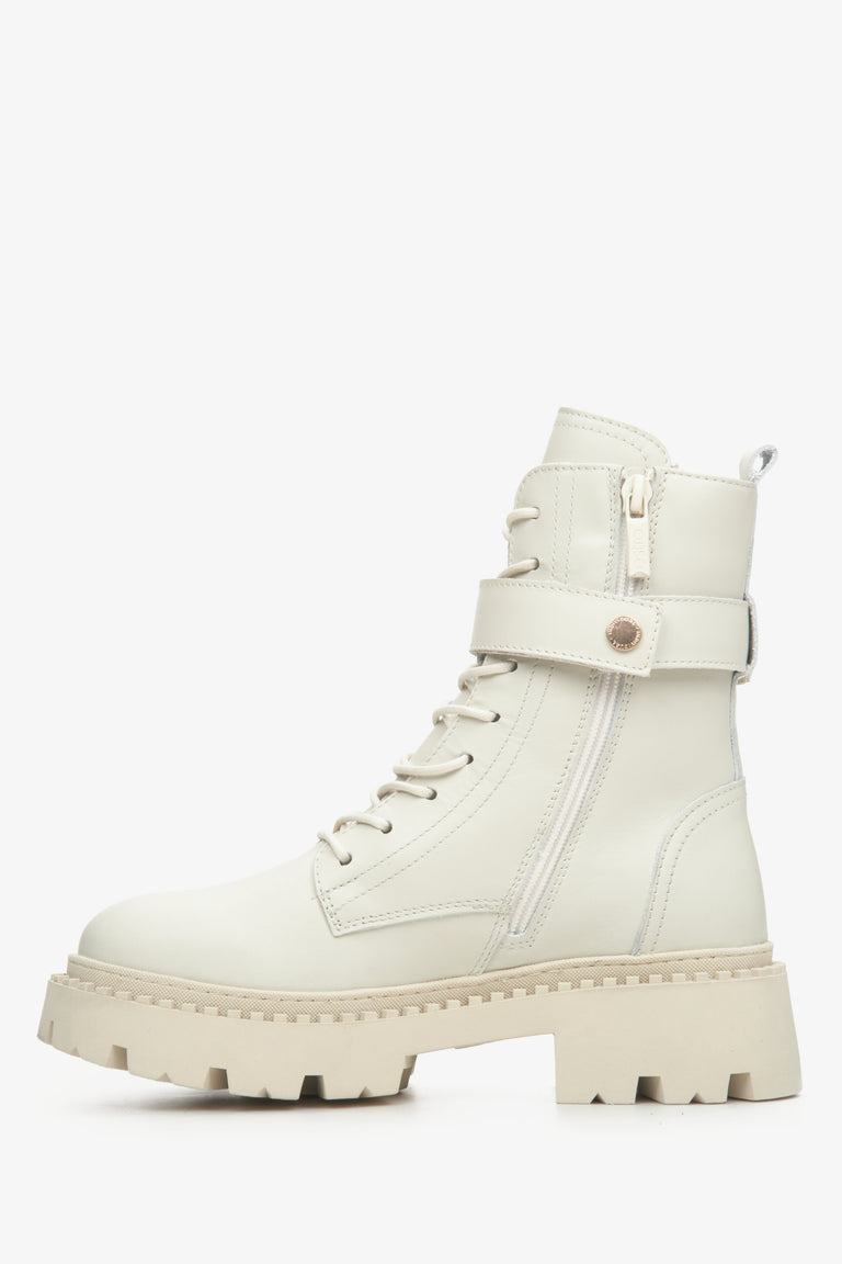 Women's leather light beige winter boots with insulation and a decorative strap - shoe profile.