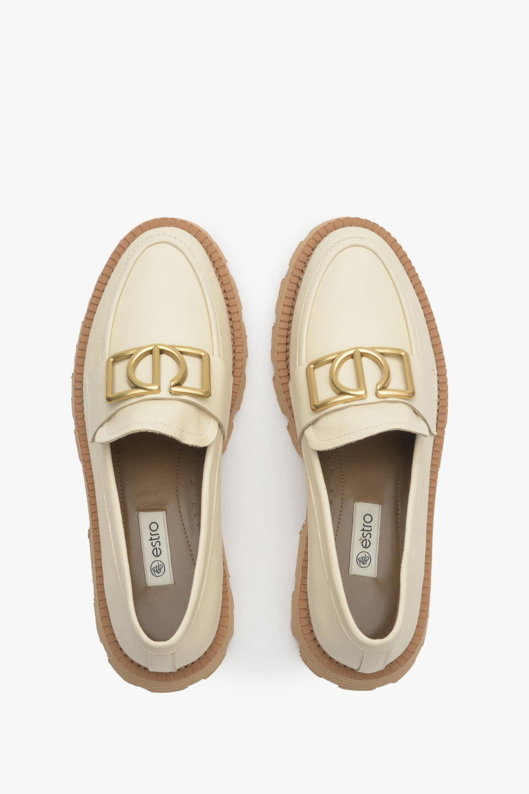 Light beige women's loafers made of natural leather with gold chain - presentation of the footwear from above.