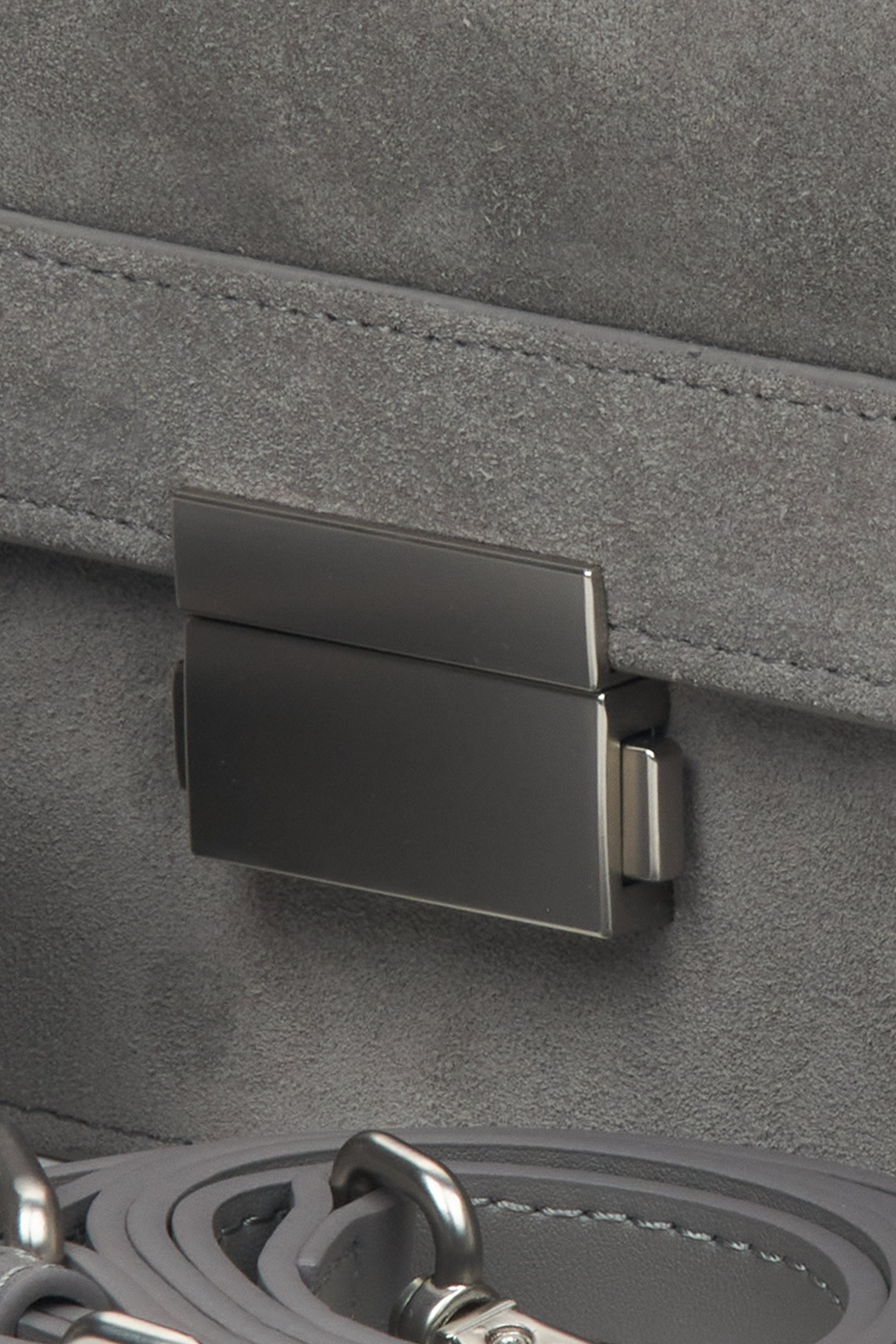 Compact women's handbag made of leather and velour in grey - close-up of the detail.