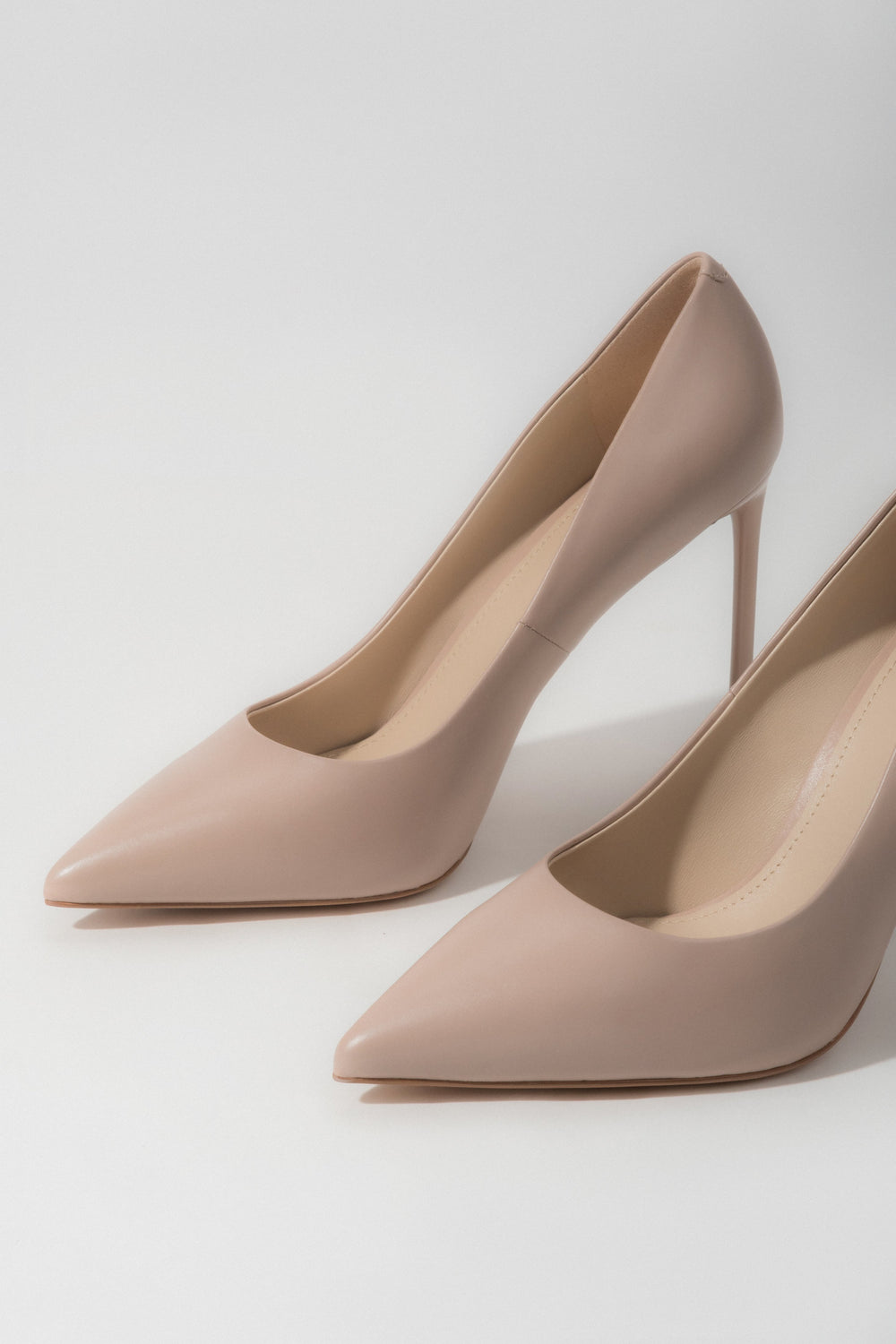 A pair of women's light beige pumps made from genuine leather with a classic high heel, by Estro.