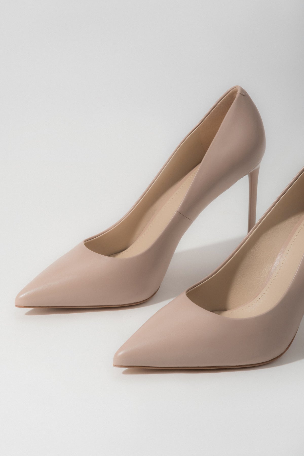 A pair of women's light beige pumps made from genuine leather with a classic high heel, by Estro.