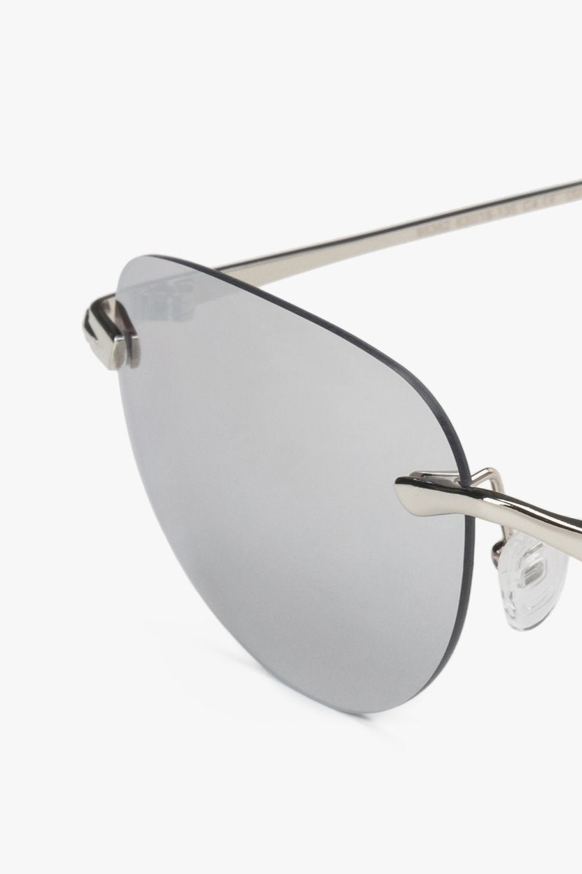 A pair of women's narrow rimless sunglasses by Estro with light grey lenses.