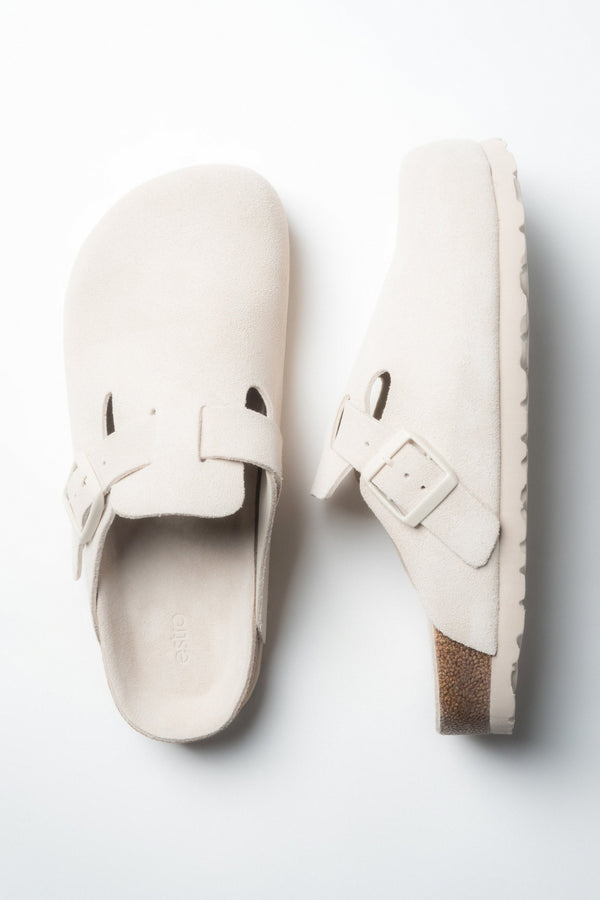 A pair of women's white slides by Estro, designed in a clog style with a soft genuine velour finish.