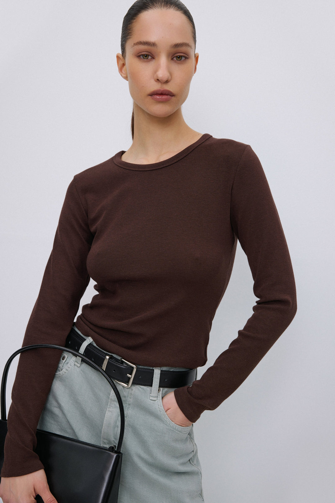 Model wearing Estro dark brown long sleeve top.